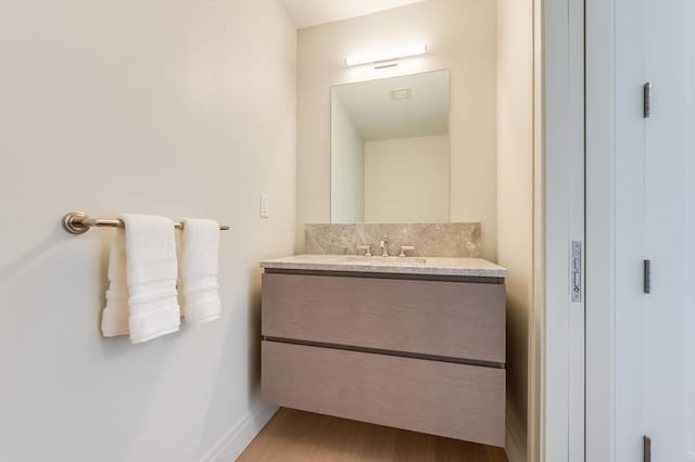 bathroom featuring baseboards, wood finished floors, and vanity