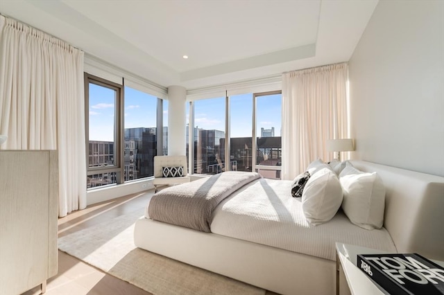 bedroom featuring multiple windows and a city view
