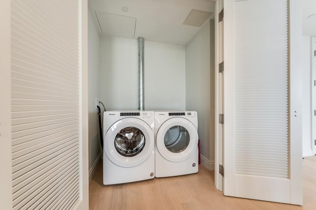 laundry area featuring washing machine and clothes dryer, laundry area, light wood finished floors, attic access, and baseboards