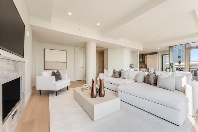 living area with a fireplace, recessed lighting, baseboards, and light wood-style floors