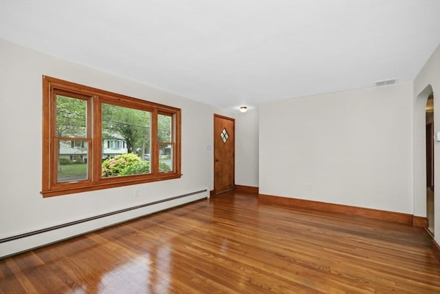 19 Chase St, Taunton, MA 02780 - empty room featuring baseboard heating, arched walkways, and wood finished floors