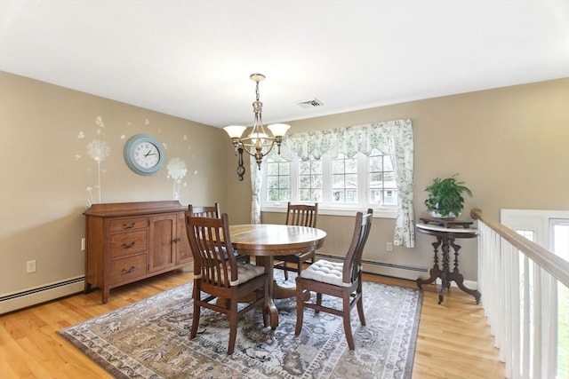 dining area featuring an inviting chandelier, visible vents, light wood-style flooring, and a baseboard heating unit