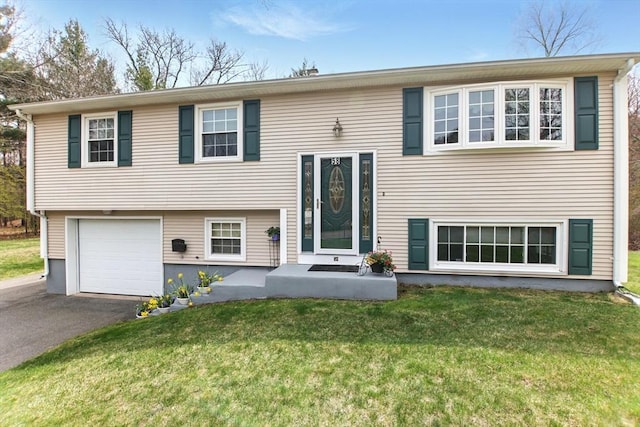 view of front of property featuring a garage, a front yard, and driveway