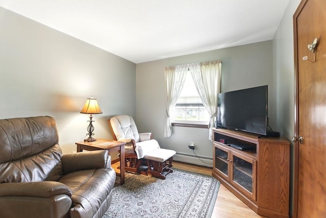 living area with light wood-style flooring and a baseboard heating unit