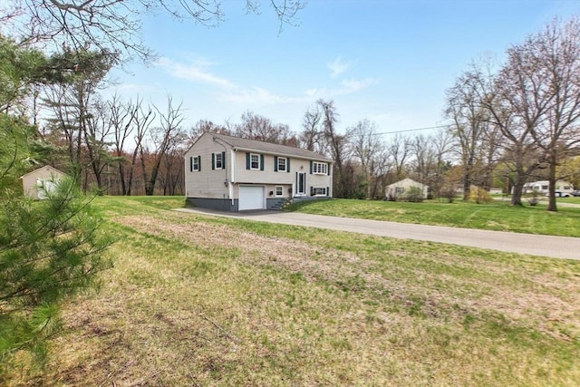 split foyer home with a chimney, a front lawn, concrete driveway, and an attached garage