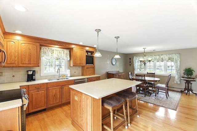 kitchen featuring a sink, a kitchen island, appliances with stainless steel finishes, and a healthy amount of sunlight