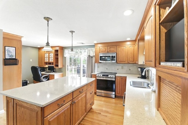 kitchen with light stone counters, open shelves, appliances with stainless steel finishes, a kitchen island, and a sink
