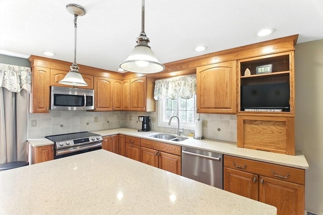 kitchen featuring stainless steel appliances, decorative light fixtures, decorative backsplash, and a sink
