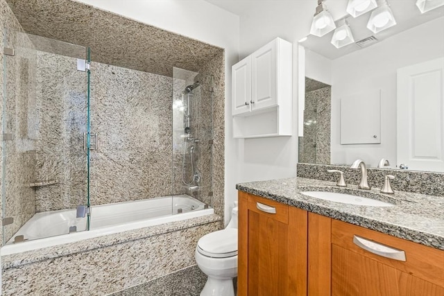 full bathroom with toilet, vanity, and bath / shower combo with glass door