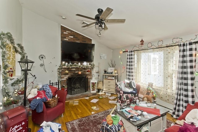 living area with visible vents, a brick fireplace, ceiling fan, lofted ceiling, and wood finished floors