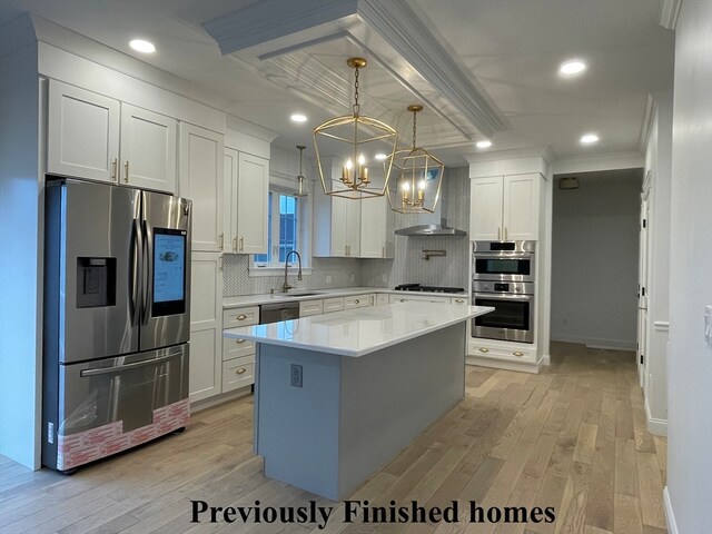 kitchen with a kitchen island, light hardwood / wood-style floors, white cabinetry, and stainless steel appliances