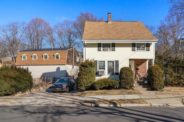 view of front of property with a chimney and a shingled roof