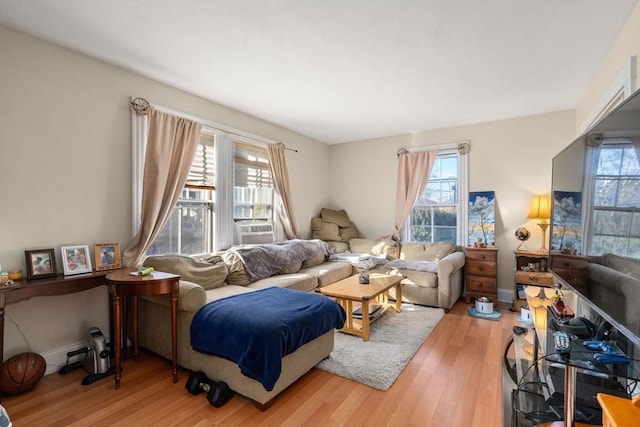 living area with baseboards and wood finished floors