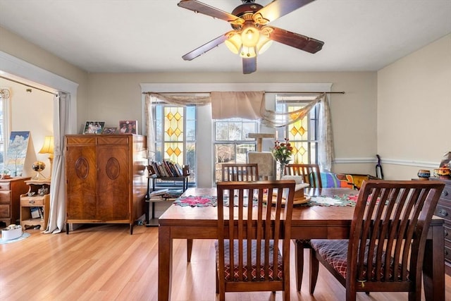 dining area featuring light wood-style flooring and a ceiling fan