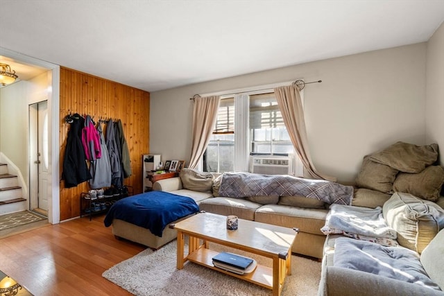 living room featuring wood walls, cooling unit, stairs, and light wood-style floors