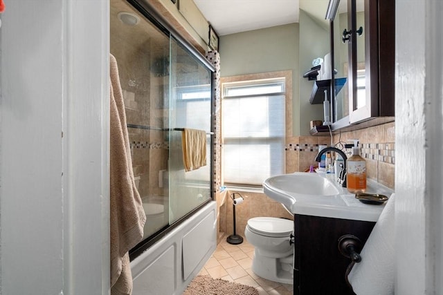 full bathroom featuring tile patterned floors, toilet, backsplash, shower / bath combination with glass door, and vanity