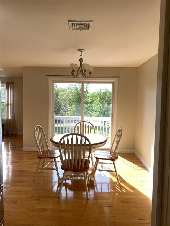 dining area featuring baseboards, a chandelier, and light wood-style flooring