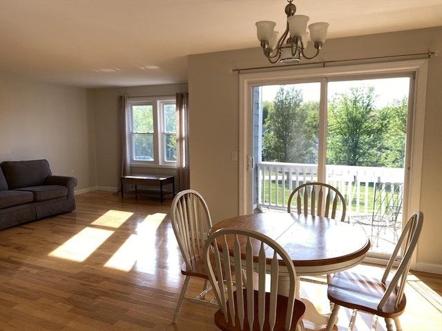 dining area featuring wood finished floors, a chandelier, and baseboards