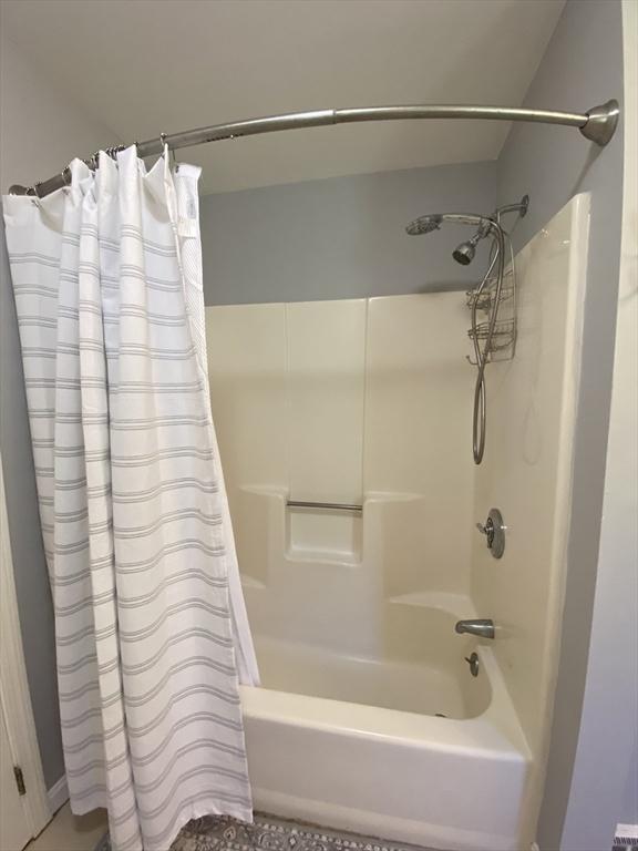 bathroom with shower / bath combination with curtain