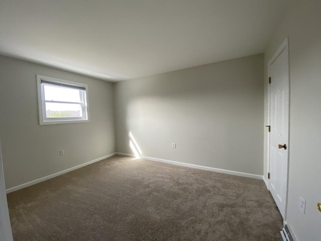 carpeted spare room featuring baseboards