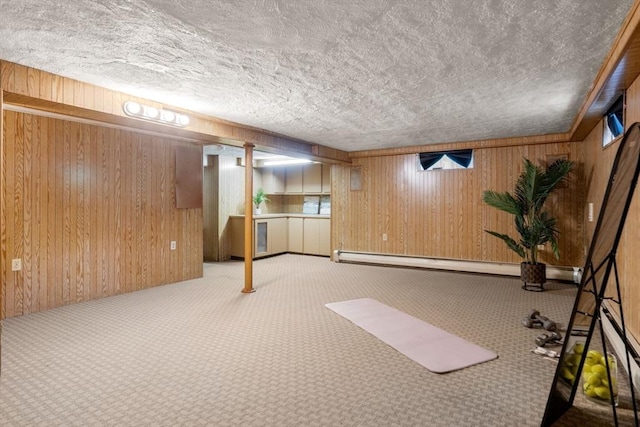 finished below grade area featuring carpet flooring, a baseboard heating unit, a textured ceiling, and wooden walls