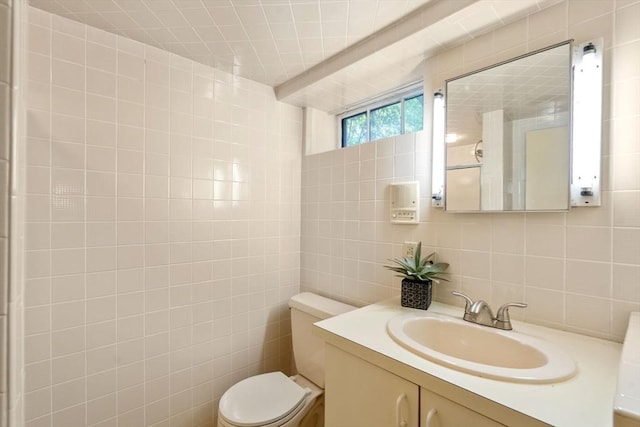 bathroom with tile walls, toilet, vanity, and decorative backsplash