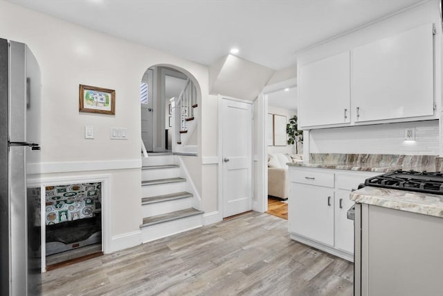 kitchen with recessed lighting, light wood finished floors, white cabinetry, and light stone countertops