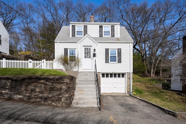 view of front of home featuring fence, a shingled roof, an attached garage, a chimney, and driveway