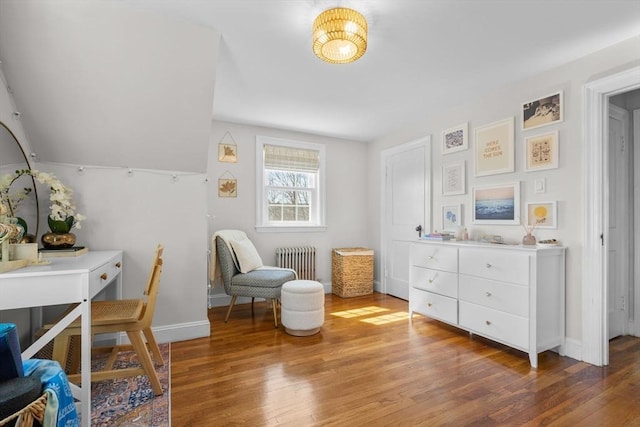 sitting room with baseboards, radiator, and light wood-type flooring