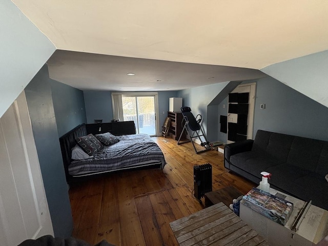 bedroom with lofted ceiling, hardwood / wood-style floors, and access to outside