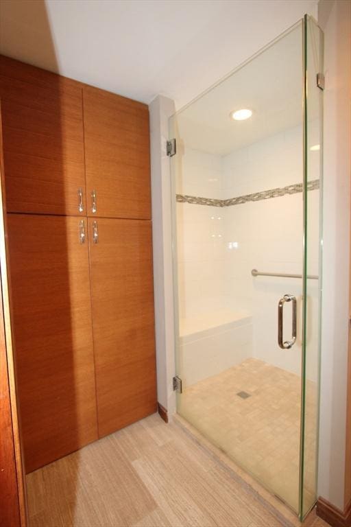 full bath with a shower stall, wood finished floors, and recessed lighting