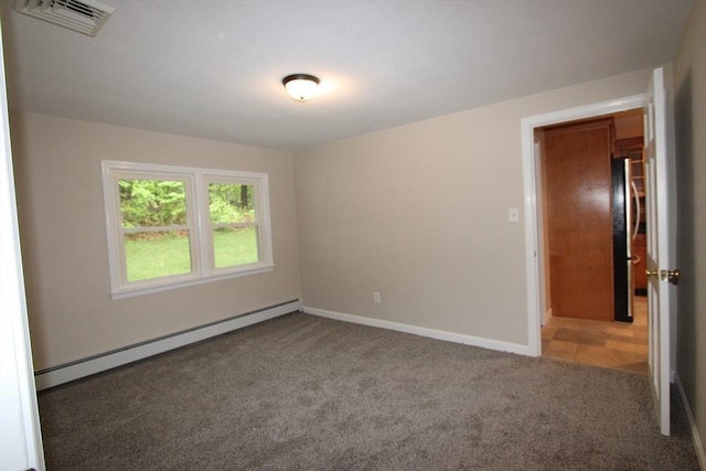 empty room featuring a baseboard heating unit, carpet floors, and baseboards