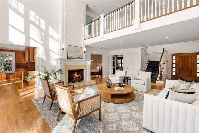 living room with light wood-type flooring and a high ceiling