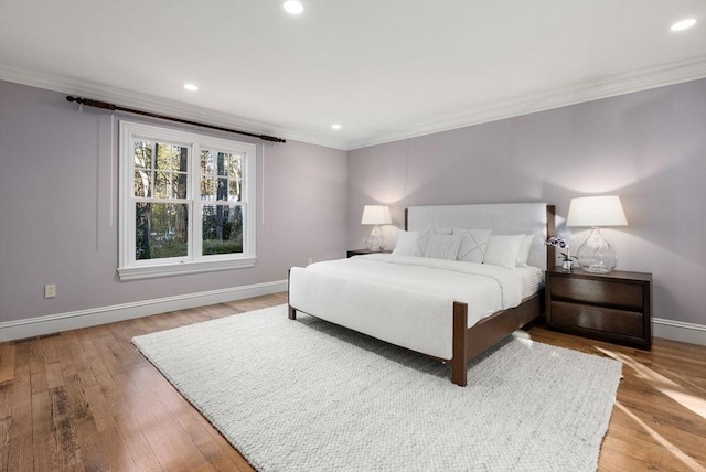 bedroom featuring wood-type flooring and ornamental molding