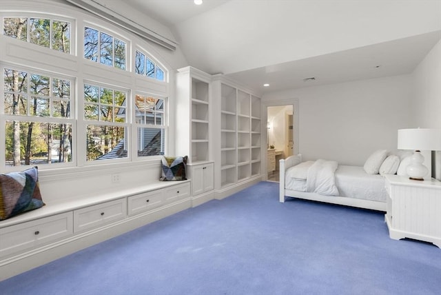 bedroom with lofted ceiling, ensuite bath, and dark colored carpet