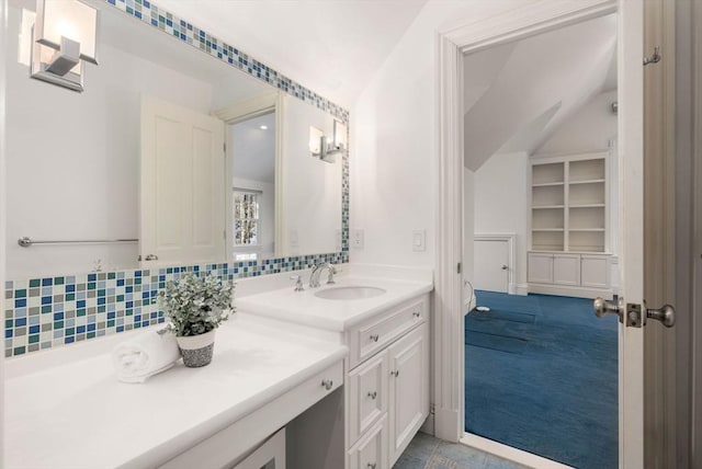 bathroom featuring lofted ceiling, vanity, and backsplash