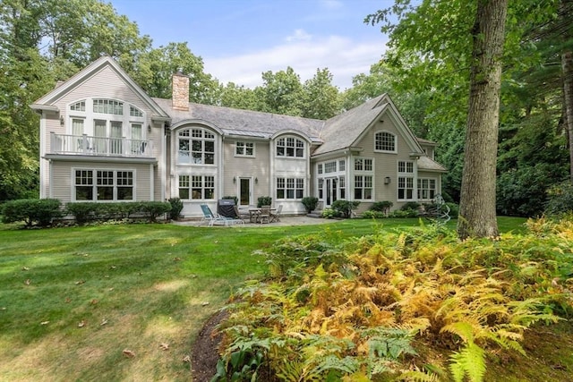 back of house featuring a balcony, a yard, and a patio area