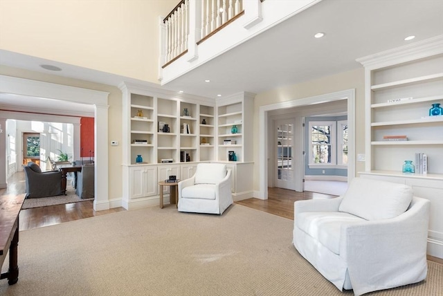 living area featuring built in features, a healthy amount of sunlight, and light wood-type flooring