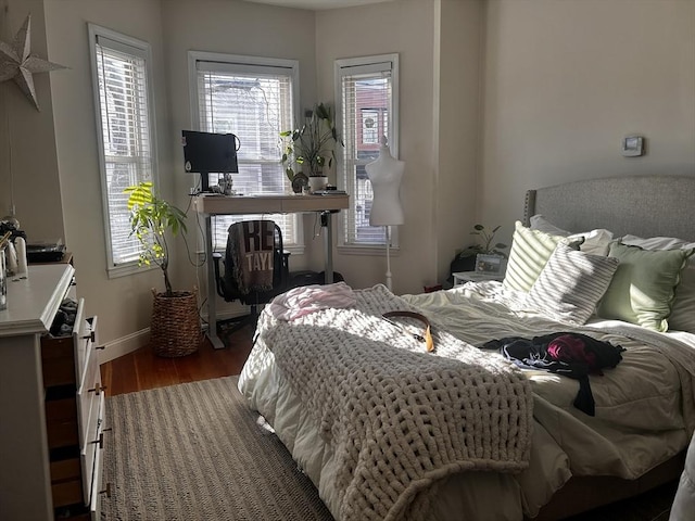 bedroom with baseboards and wood finished floors