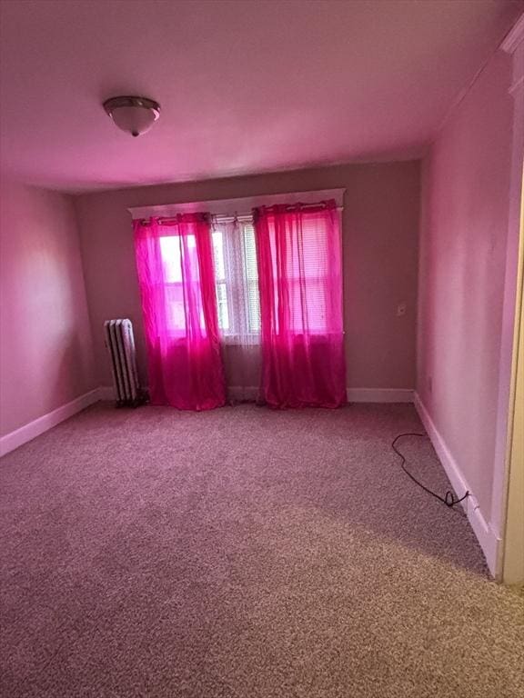 empty room featuring radiator heating unit and carpet floors