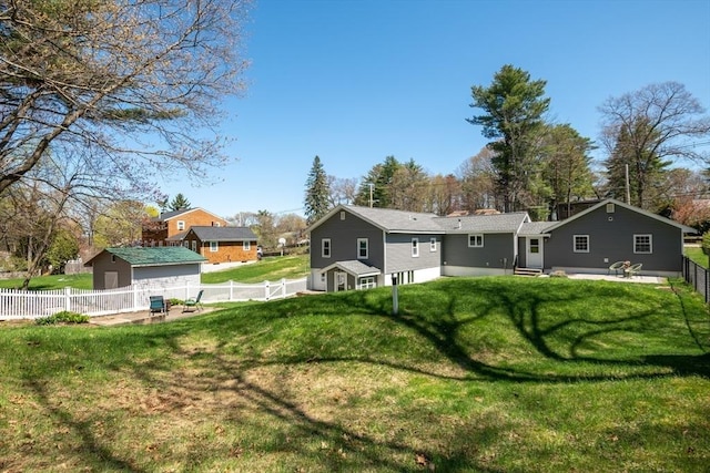 rear view of property with a fenced backyard, a lawn, and entry steps