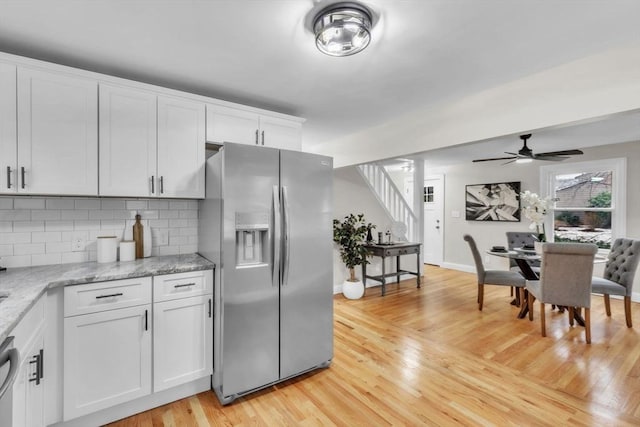 kitchen featuring white cabinetry, stainless steel appliances, light stone countertops, and light hardwood / wood-style floors