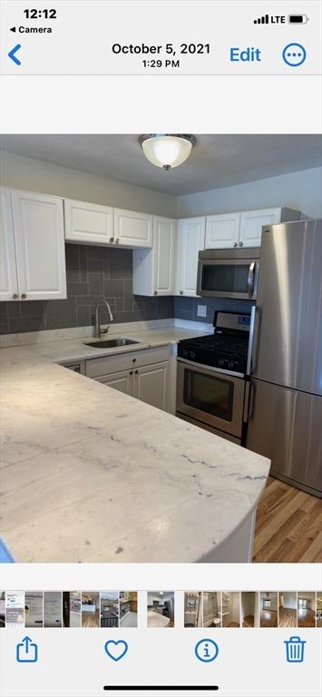 kitchen with white cabinetry, sink, tasteful backsplash, wood-type flooring, and appliances with stainless steel finishes