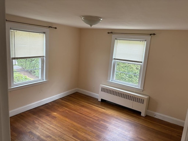33 Meadowbrook Rd, Brookline, MA 02467 - spare room featuring radiator heating unit, healthy amount of natural light, and wood finished floors