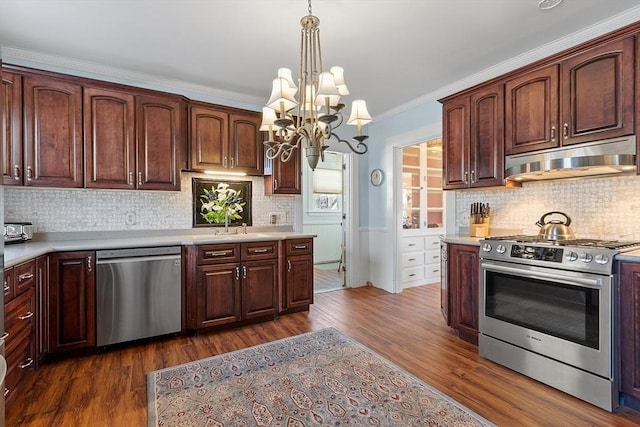 kitchen featuring tasteful backsplash, decorative light fixtures, ornamental molding, dark hardwood / wood-style floors, and appliances with stainless steel finishes