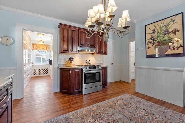 kitchen with stainless steel gas range oven, crown molding, wood-type flooring, a chandelier, and pendant lighting