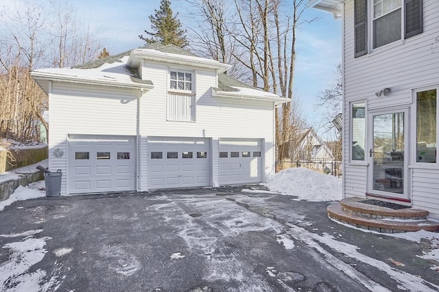 view of snowy exterior with a garage