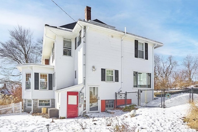 view of snow covered rear of property