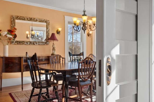 dining room featuring a notable chandelier, ornamental molding, and hardwood / wood-style floors