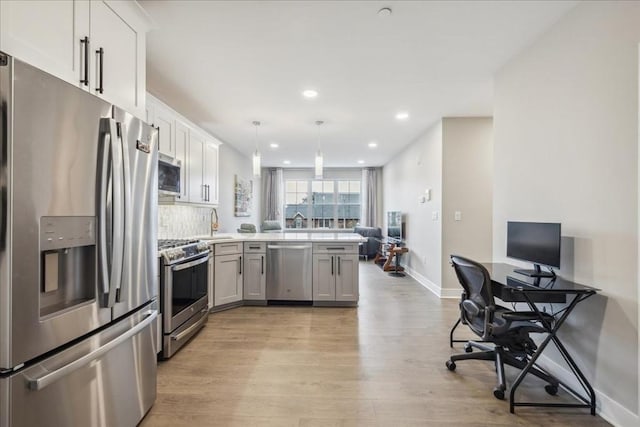 kitchen with appliances with stainless steel finishes, white cabinets, light hardwood / wood-style floors, and decorative light fixtures